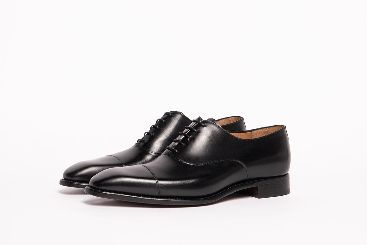 Carlos Santos 8627 Cap-Toe Oxford in Black Calf with full grain calfskin uppers and leather sole on a white background.